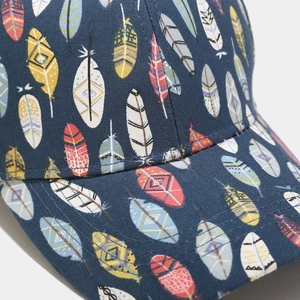 Detailed close-up of neat stitching and colorful feather patterns on a cotton baseball cap