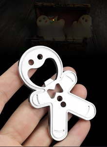Detailed view of gingerbread man bottle opener in polished silver finish being held