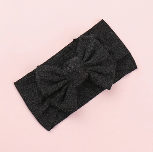 Detail of soft ribbed knit texture and large bow on dark grey baby headband