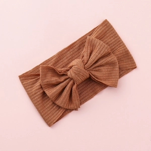 Macro detail of brown knitted baby headband with a large ribbed texture bow