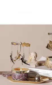Detail eines goldenen rotierenden Kerzenhalters mit Feen-Anhängern und lila Basis
