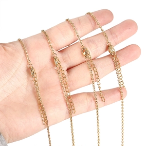 Vue rapprochée de chaînes d'extension en acier inoxydable doré et fermoirs pour bijoux.