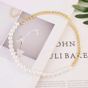 Detail of a multi-layer gold chain necklace with baroque pearls on a magazine