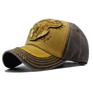 Close-up of a washed canvas baseball cap with mustard bull embroidery and contrast panels