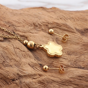Golden starfish jewelry set with flower pendant necklace and stud earrings on wood