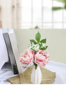 Pink silk peonies in a white ceramic vase on books for home and wedding decor