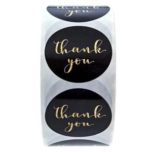 Roll of 1 inch black round thank you stickers with gold foil lettering for packaging