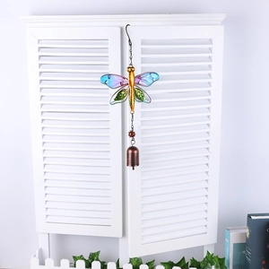Detailed close-up of a metal dragonfly wind chime with colorful stained glass wings