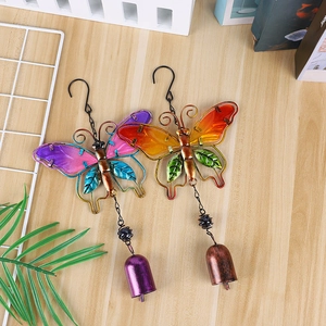 Detailed macro view of colorful metal butterfly wind chimes on a rustic wooden tabletop