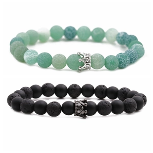 Detail view of crown charms on volcanic lava stone and green agate beaded bracelets