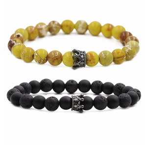 Detail of 8mm lava rock and turquoise beads with crown charm on a white background