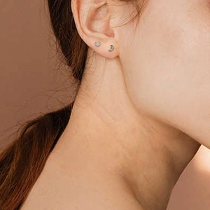 Close-up of S925 sterling silver star and moon stud earrings with sparkling cubic zirconia