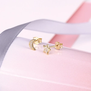 Detail of S925 silver moon and star stud earrings with gold plating and sparkling zircons