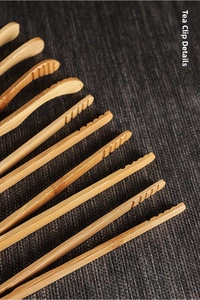 Close-up of bamboo tea tongs with flat and curved tips featuring non-slip grooves