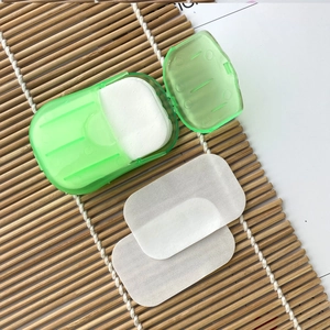Outdoor disposable soap paper sheets in a green portable case on a bamboo mat background
