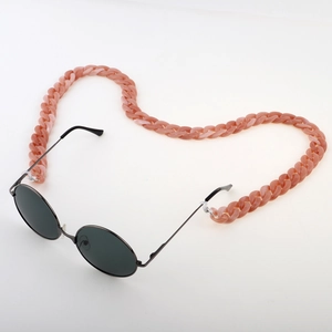 Pink acrylic tortoiseshell chain with round black sunglasses on a white background
