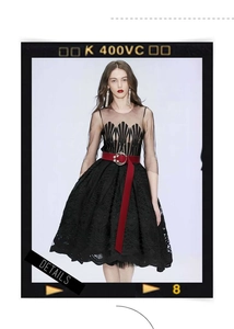 Détail d'une ceinture corset en cuir rouge avec boucle perle sur robe dentelle noire