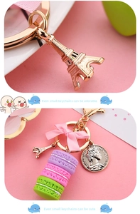 Close-up of macaron keychain with pink bow, Eiffel Tower charm, and gold coin pendant