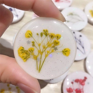 Macro shot of handmade resin phone socket with yellow dried flowers and gold glitter flakes