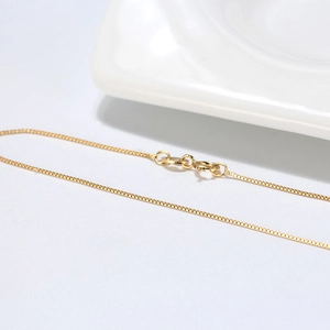 Macro shot of gold-plated S925 sterling silver box chain necklace with a spring ring clasp