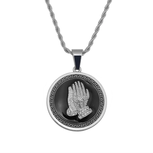 Detailed shot of hip hop prayer hands pendant with silver greek key pattern and stones