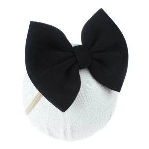 Vue détaillée d'un bandeau pour bébé avec un grand nœud noir en tissu sur dentelle