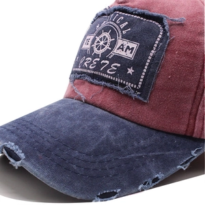 Close-up of vintage red and blue baseball cap with nautical team patch and distressed brim