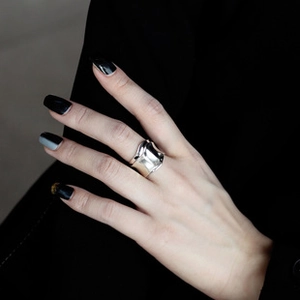 Close-up of a minimalist wide silver S925 ring on a finger with professional lighting
