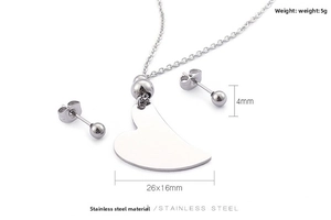 Detailed view of stainless steel heart pendant necklace and matching ball stud earrings
