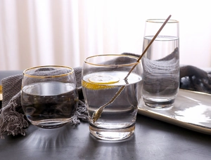 Detailed view of luxury gold-rimmed glassware set including egg-shaped and tall glass cups