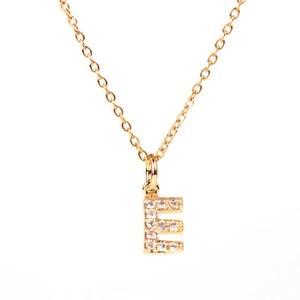 Detailed view of a gold-plated necklace with a crystal-studded letter E pendant
