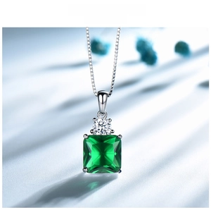 Macro shot of square emerald green gemstone pendant with micro-paved silver detail