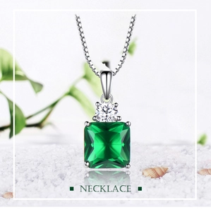 Detailed macro view of square emerald pendant on a silver chain with white diamonds