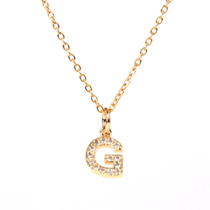 Detail of gold letter G pendant necklace with micro-pave sparkling crystal rhinestones