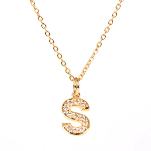 Macro shot of gold-plated S-letter pendant necklace with sparkling pavé zircons