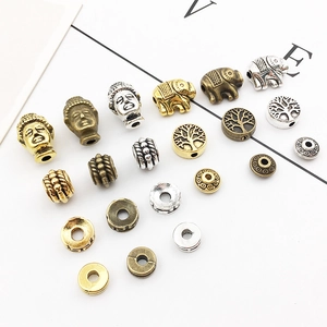 Macro shot of antique gold and silver alloy elephant and Buddha spacer beads for DIY jewelry