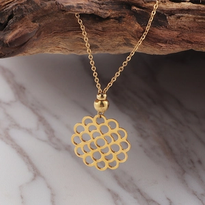 Élégant collier avec pendentif fleur évidée plaqué or 18K sur fond bois rustique