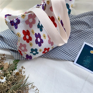Dettaglio della borsa tote in crepe floreale con chiusura magnetica e trama a pieghe