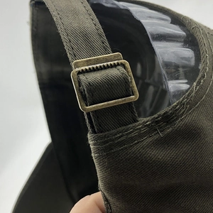 Makro-Detail der olivgrünen Baseballkappe mit verstellbarer Metallschnalle aus Bronze