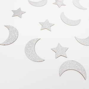 Macro shot of silver glitter stars and moon confetti for party and wedding decoration