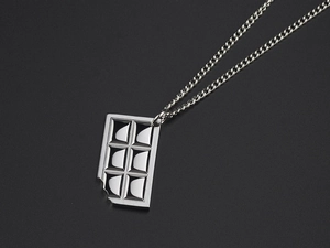 Detailed close-up of a silver titanium steel necklace featuring a bitten chocolate pendant