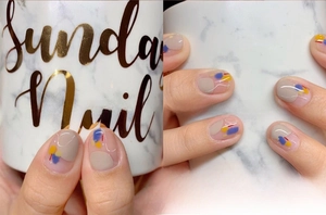 Detail of artistic abstract nail stickers with yellow and blue color blocks on nails