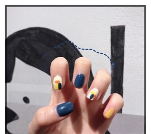 Detail of 3D nail art stickers featuring modern abstract color blocks in blue and yellow