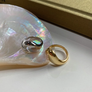 Detail of 925 sterling silver teardrop and streamlined rings on a pearl shell