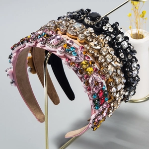 Detailed close-up of crystal-embellished headbands in vibrant colors on a gold rack