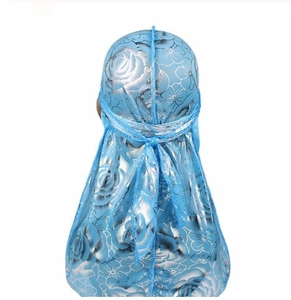 Detail view of silky blue durag with floral rose patterns and long ties on back