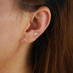 Close-up of S925 silver safety pin and crown earrings with micro-paved cubic zirconia