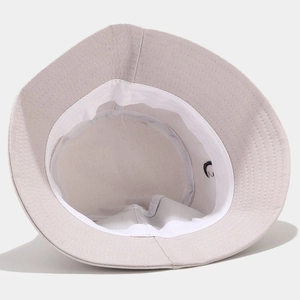 Vista dettagliata dell'interno del cappello a secchiello in cotone beige con cuciture