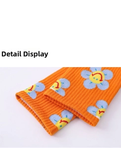 Detailed macro view of orange knitted cotton socks with blue and yellow sunflower patterns