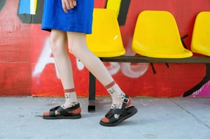 Detail of transparent cat print socks with contrast brown knit toes and sandals